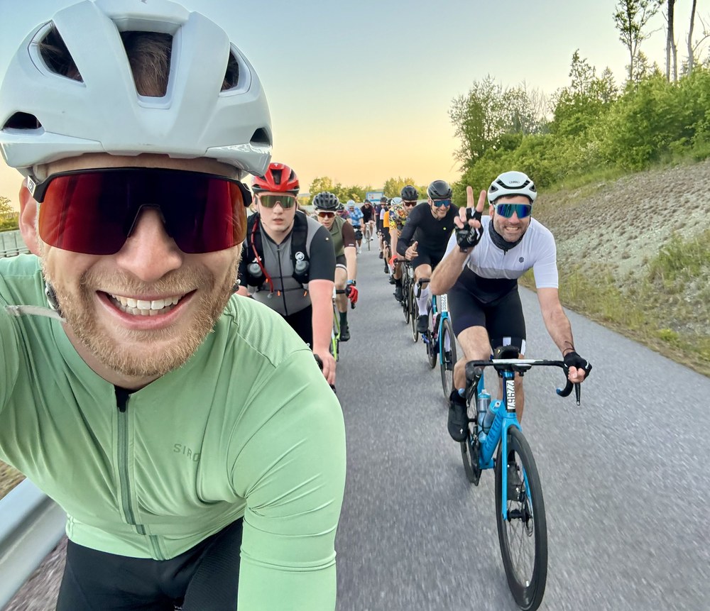 Sven on a dawn group road ride, golden light behind a line of cyclists