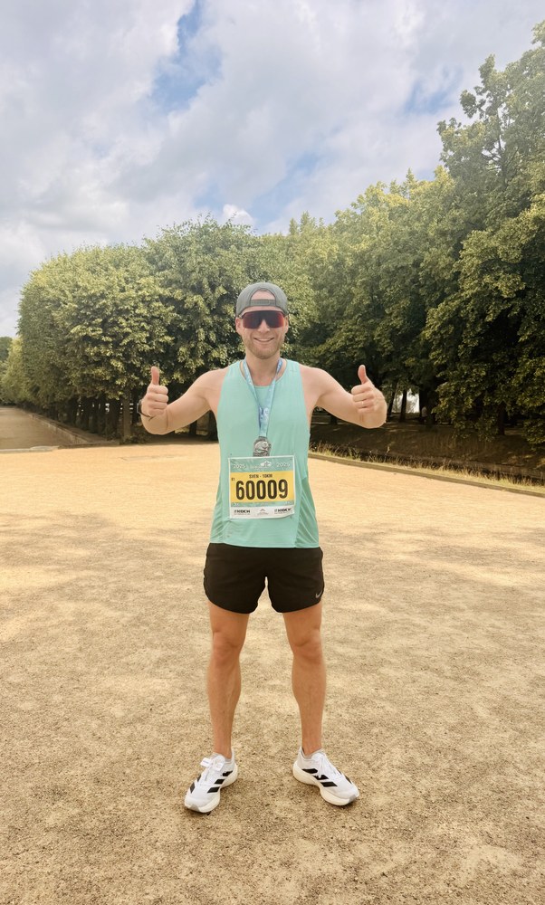 Sven giving two thumbs up after a road race on a tree-lined gravel avenue at Versailles